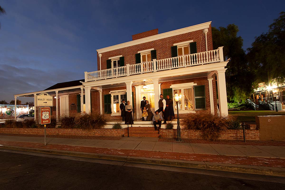 Colonial house with people in old style clothing standing outside